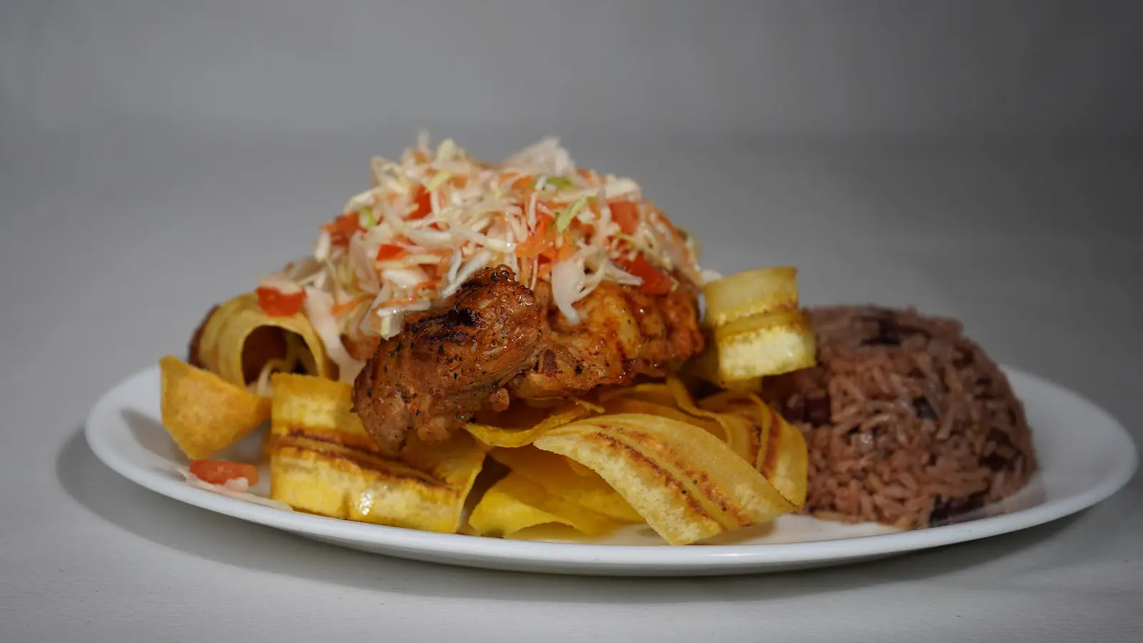 Plato nicaragüense de El Jicarito con gallo pinto, tajadas de plátano y ensalada de repollo