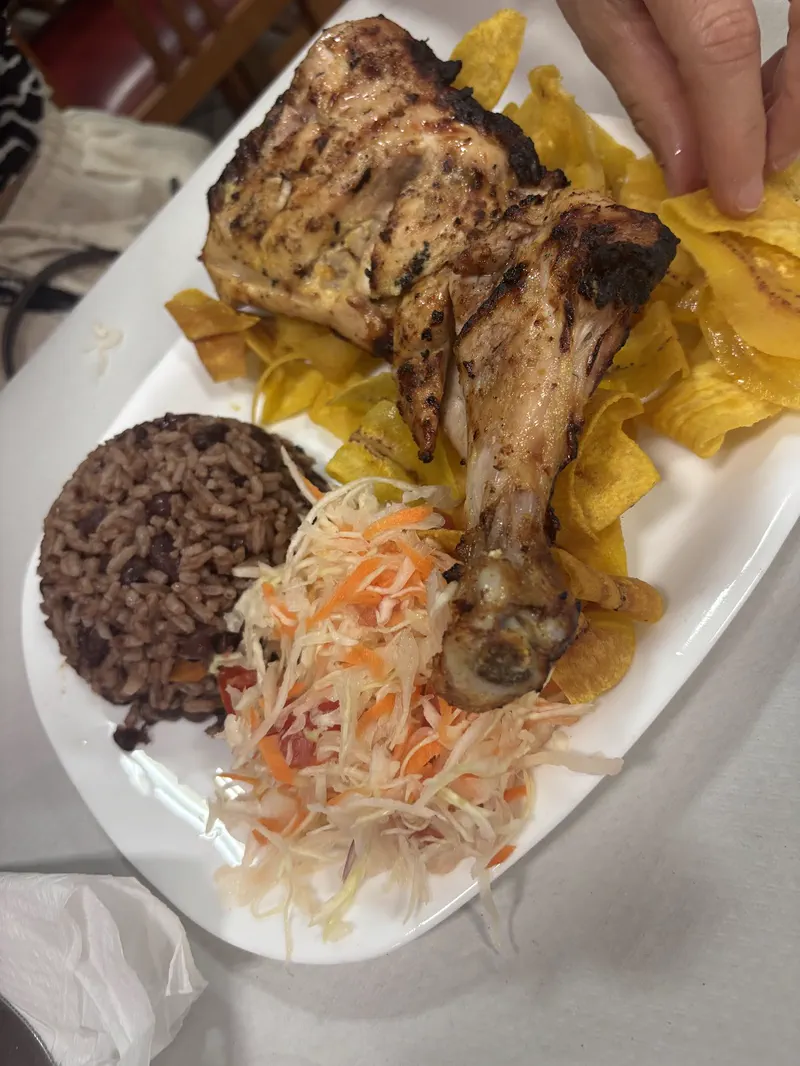 Pollo asado con gallo pinto, tajadas de plátano y ensalada en una mesa de El Jicarito