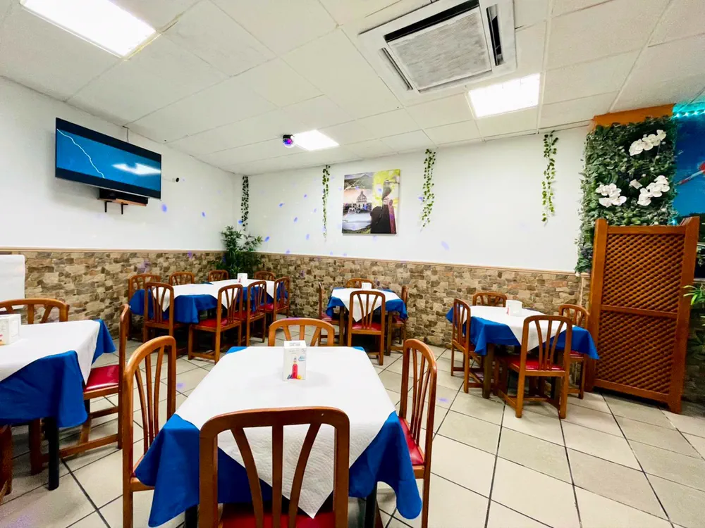 Salón de El Jicarito con manteles azules y blancos